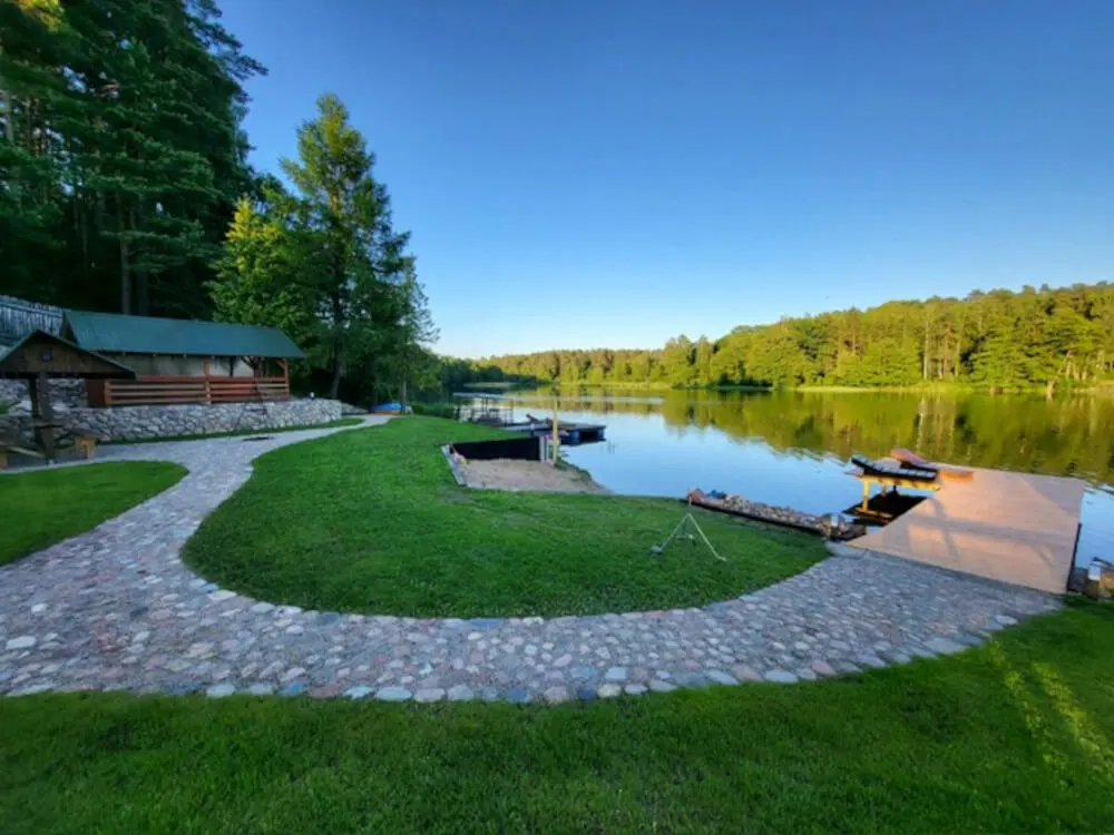 Kamienna ścieżka pośród zielonej trawy prowadząca do dużego pomostu