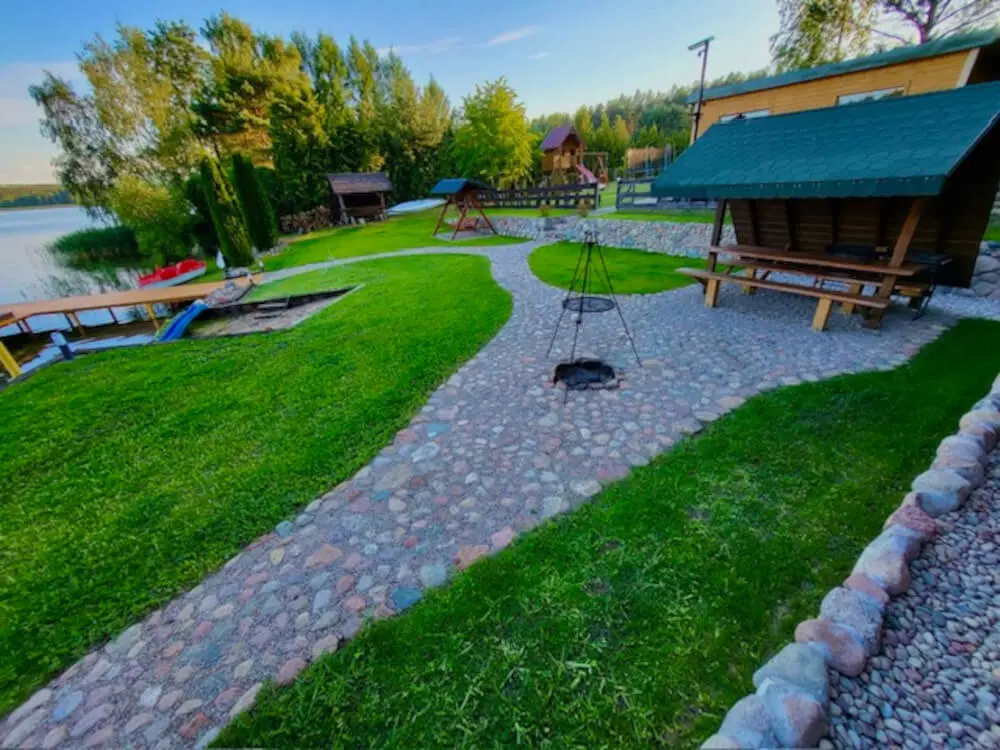 Miejsce na ognisko nad jeziorem, z drewnianą ławką i stołem pod zadaszeniem