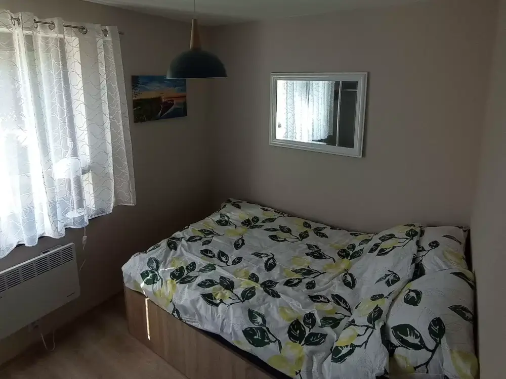 Komfortowa sypialnia z podwójnym łóżkiem i dużym oknem