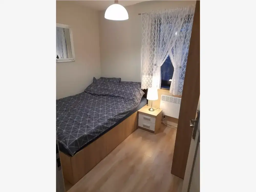 Przytulna sypialnia z dużym łóżkiem i szafą