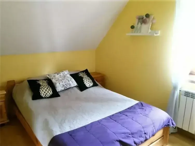 Przytulna sypialnia z podwójnym łóżkiem, dużą szafą i oknem z widokiem na las