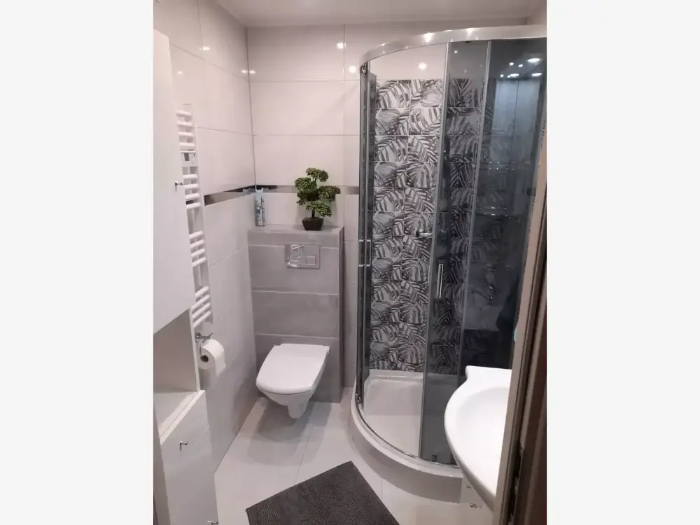 Nowoczesna łazienka z kabiną prysznicową, umywalką i toaletą